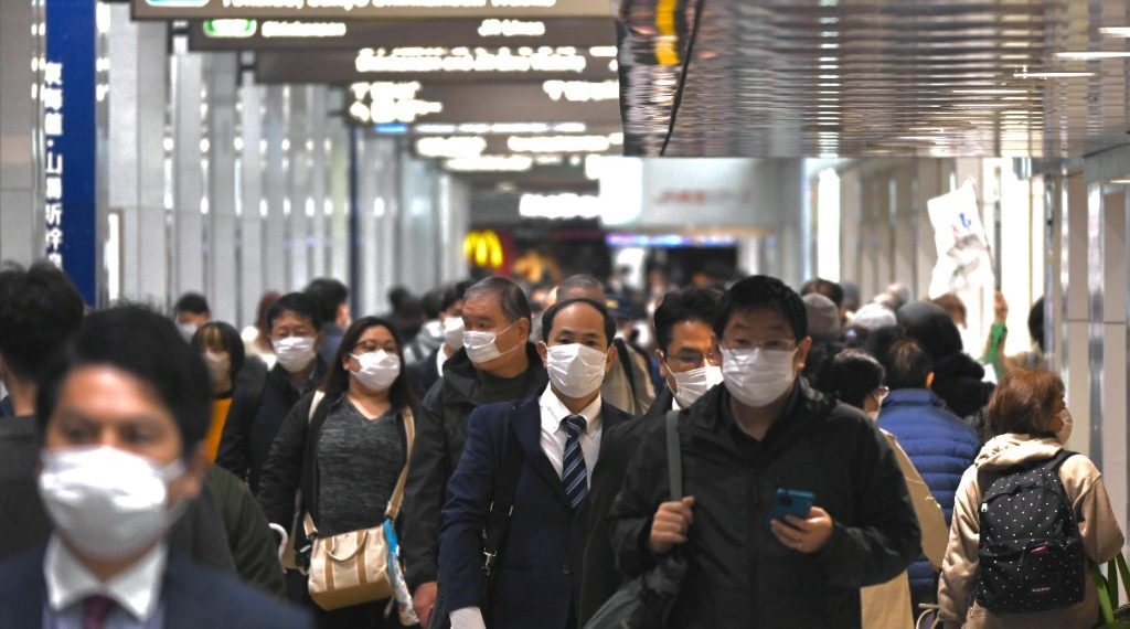 行人在日本东京站穿行。