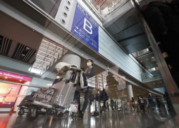 2023年1月8日，旅客推行李走出北京首都国际机场T3航站楼国际到达出口。