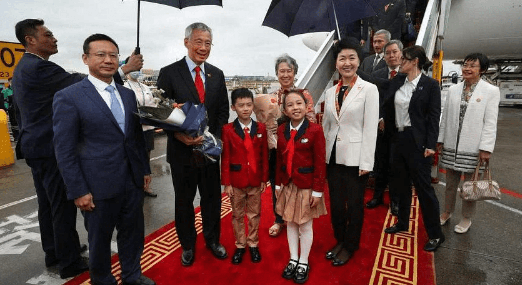 李显龙(左三)在妻子何晶(中后)的陪同下抵达广州白云国际机场。