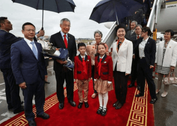 李显龙（左三）在妻子何晶（中后）的陪同下抵达广州白云国际机场。