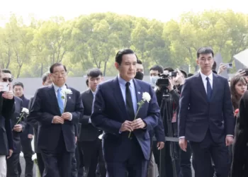 马英九手持白菊走向“古城的灾难”雕塑献花。