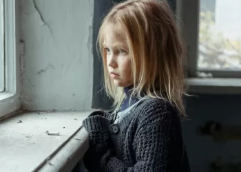 depressed-poor-girl-standing-near-window
