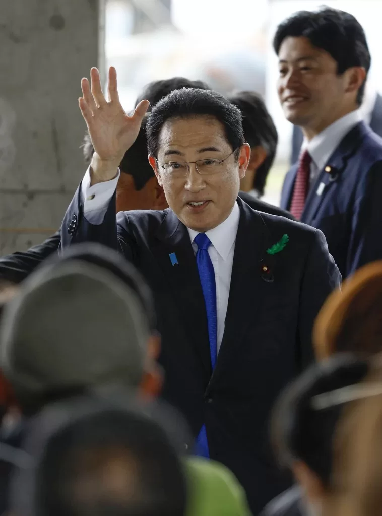 4月15日，在日本和歌山县和歌山市杂贺崎渔港，日本首相岸田文雄向现场人群挥手致意。