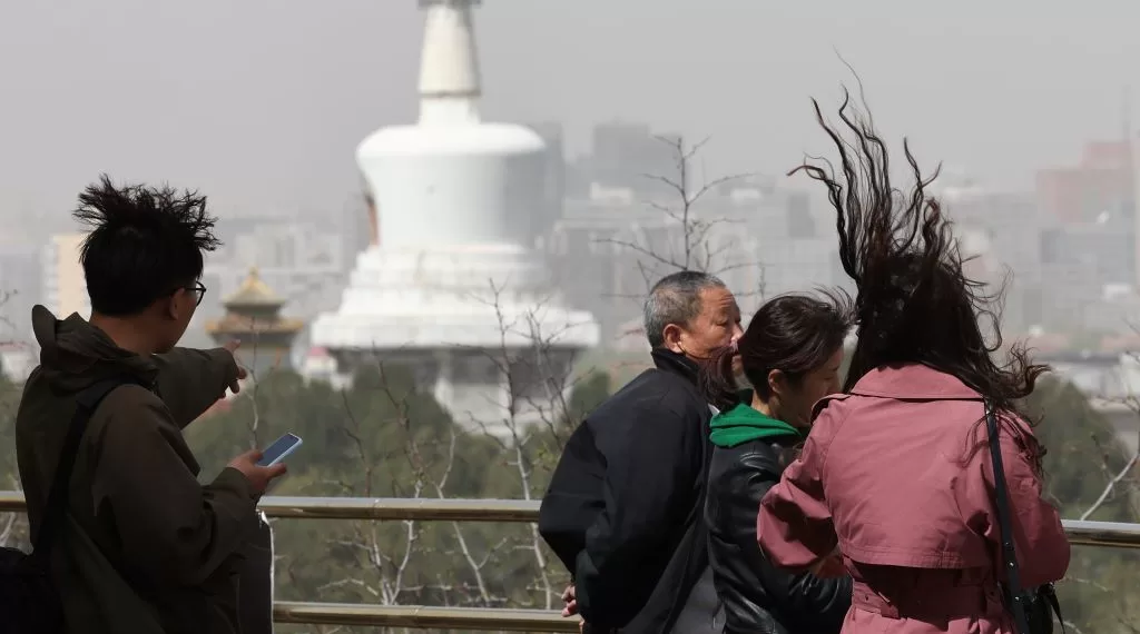 4月11日，北京遭遇大风和沙尘天气，市民游览景山公园时头发被大风吹起。