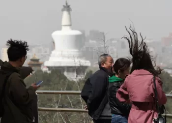4月11日，北京遭遇大风和沙尘天气，市民游览景山公园时头发被大风吹起。