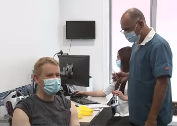 总理克里斯·希普金斯在上哈特的皇后街医疗中心接种流感疫苗和 Covid 加强剂。