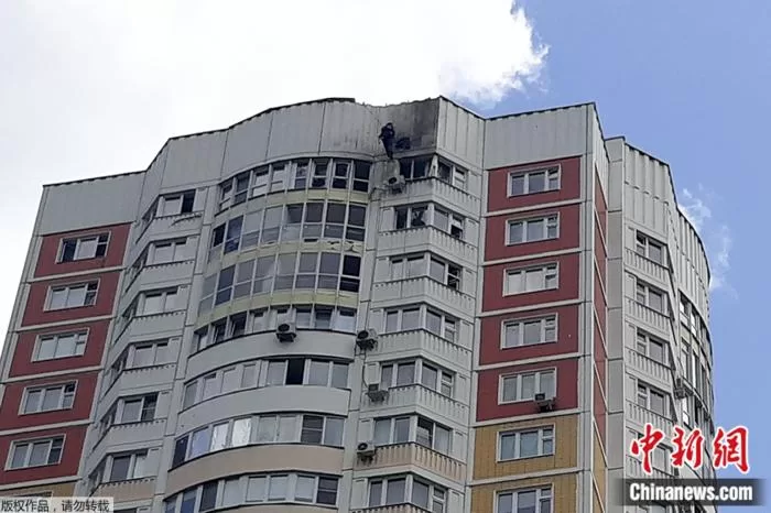 当地时间5月30日，俄罗斯莫斯科，一名调查人员在无人机袭击一栋公寓楼后，检查损坏情况。