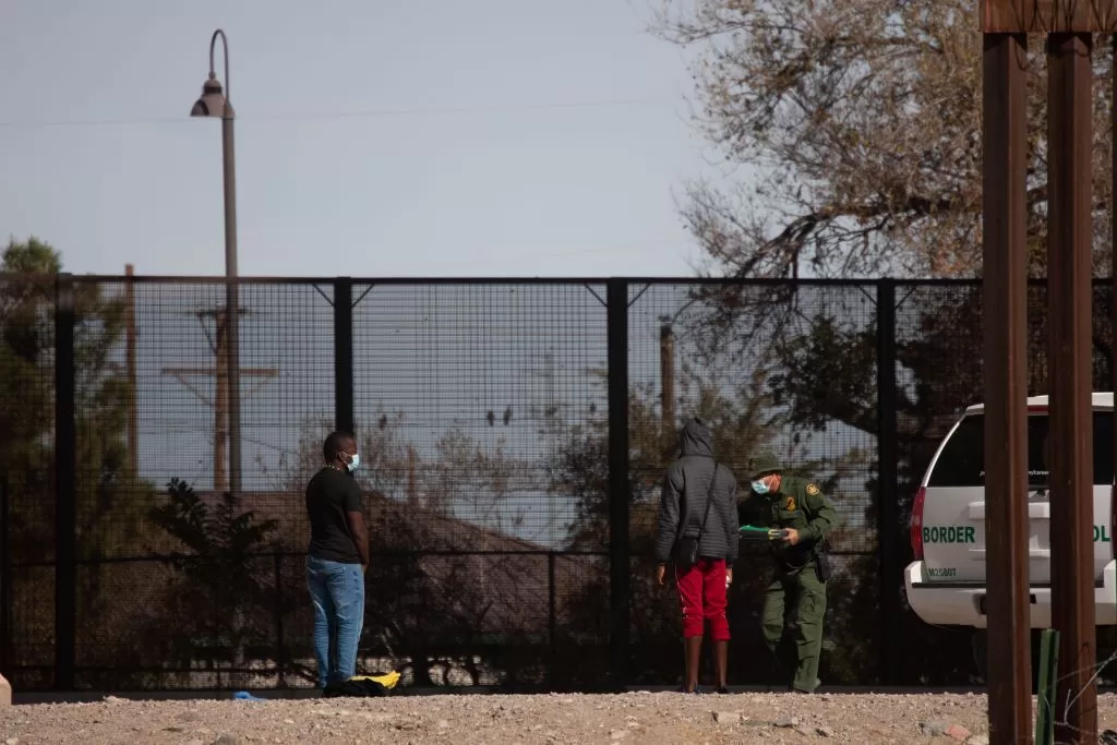 2021年12月7日在墨西哥华雷斯城拍摄的照片显示，试图翻越边境墙进入美国的移民被美国边境执法人员拦截。