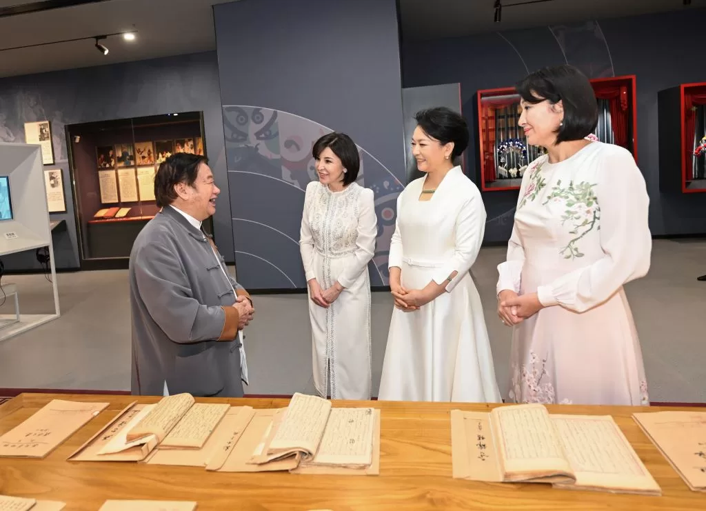 这是在易俗社百年手抄剧本展区，彭丽媛和来宾们参观秦腔剧本手稿。