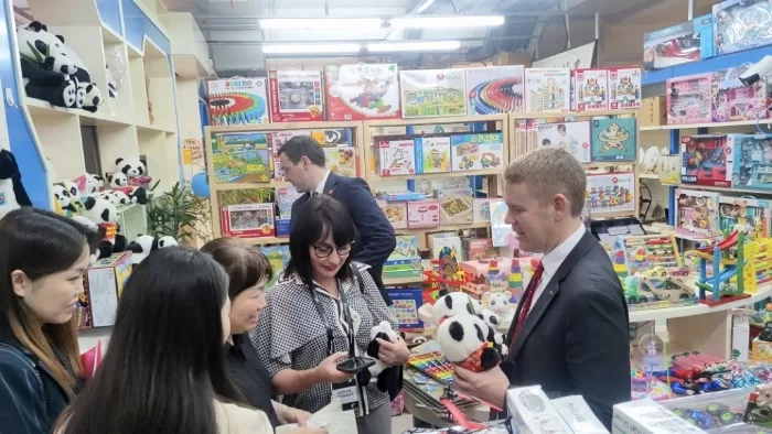 希普金斯在北京秀水街买熊猫毛公仔做手信。