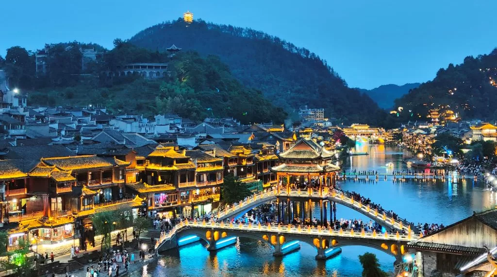 6月15日,众多游客在湖南凤凰古城的雪桥上游玩。此桥由黄永玉出资捐建。