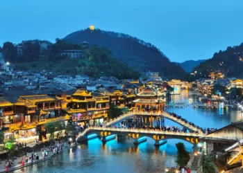 6月15日，众多游客在湖南凤凰古城的雪桥上游玩。此桥由黄永玉出资捐建。