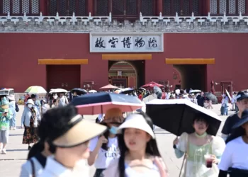 6月22日，北京故宫博物院游客撑伞、戴遮阳帽防晒。
