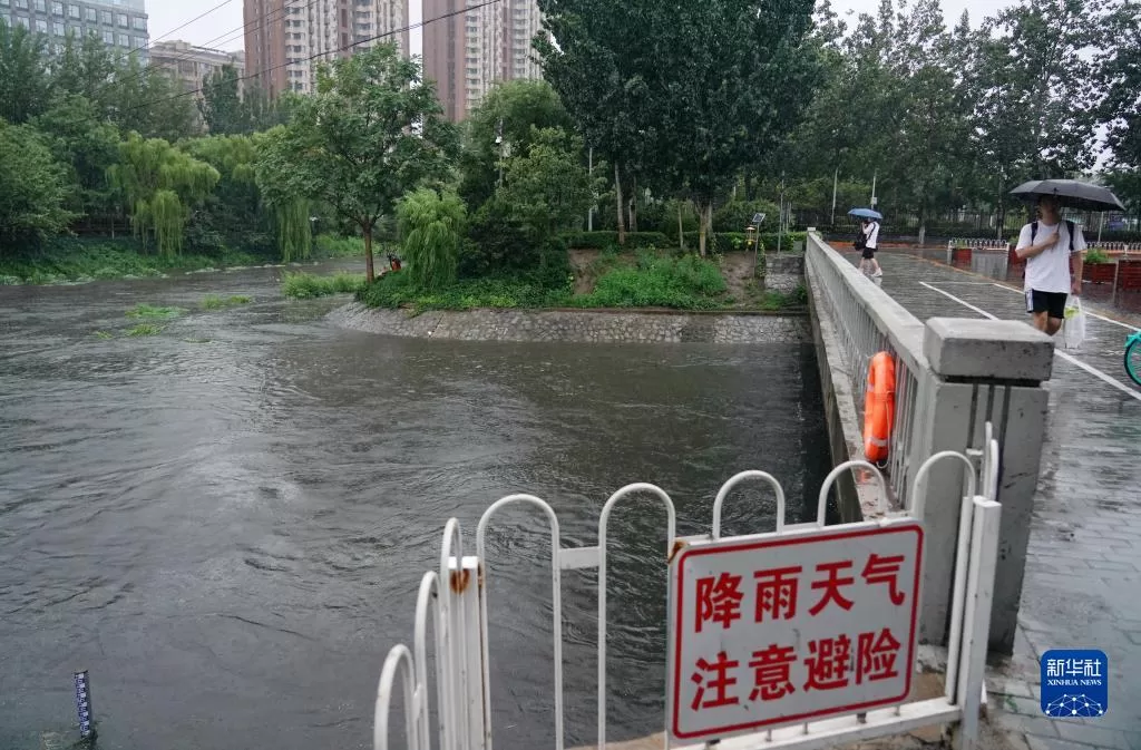 7月30日，在北京市凉水河周边，市民冒雨出行