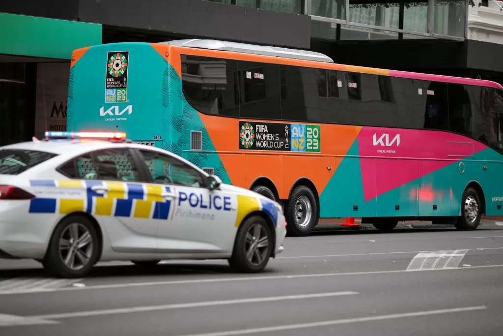 7月20日，在新西兰奥克兰，警车经过一辆女足世界杯专用巴士。