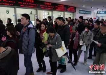 民众在某医院门诊楼内排队挂号。