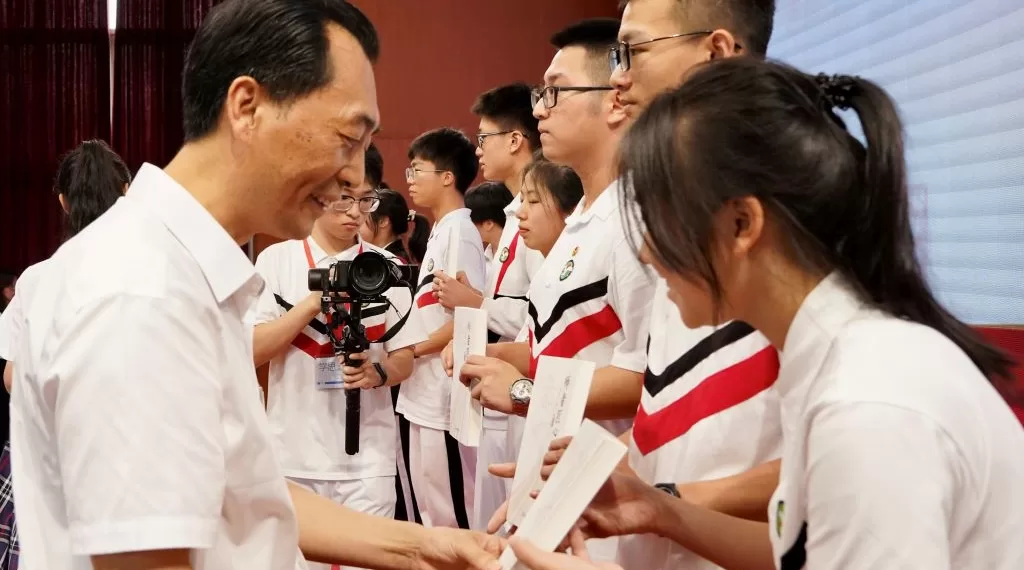 陈俊才校长向中学生赠阅《师者匠心》。