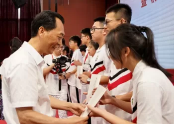 陈俊才校长向中学生赠阅《师者匠心》。