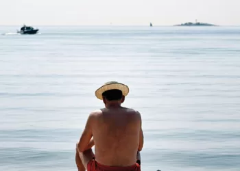 6月15日，一名男子在芬兰赫尔辛基的海边晒太阳。