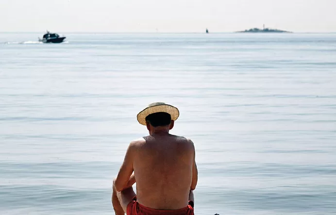 6月15日,一名男子在芬兰赫尔辛基的海边晒太阳。