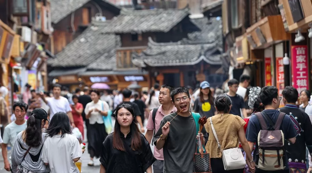 10月1日,游客在西江千户苗寨景区游玩。 今年中秋、国庆8天假期,中国热门城市和景区人潮涌动,旅游市场火热。